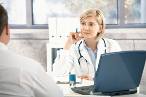Doctor listening to patient with concentration, sitting at desk